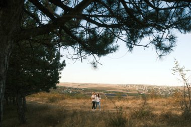 A loving couple enjoys a serene and peaceful moment together in a beautiful landscape beneath a big tree