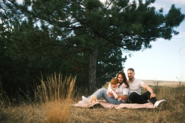 A loving family enjoys a cozy outdoor moment, capturing their affection and cherishing their beautiful bond