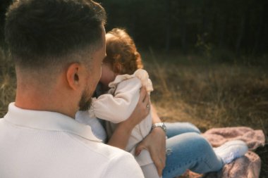 A truly heartwarming and touching moment shared between a loving parent and their child in a serene outdoor setting