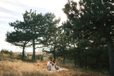 A serene and tranquil moment of a loving couple enjoying the beauty of nature under tall trees in a peaceful landscape