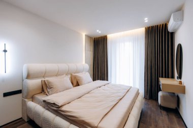 A stylish bedroom with a soft bed, natural light, and modern decor that embodies comfort and relaxation