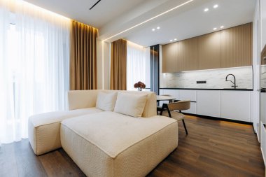 This chic and modern living space showcases a stylish sofa complemented by a contemporary kitchen design