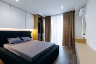 A stylish and modern bedroom that showcases sleek design, ample natural light, and elegant decor elements