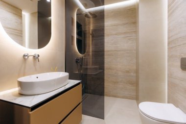 This stylish and modern bathroom showcases an elegant sink, contemporary fixtures, and soothing ambient lighting
