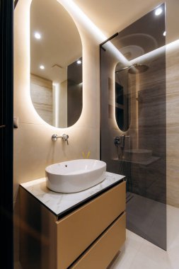 An elegant bathroom that features a sleek contemporary design, modern fixtures, and soft ambient lighting