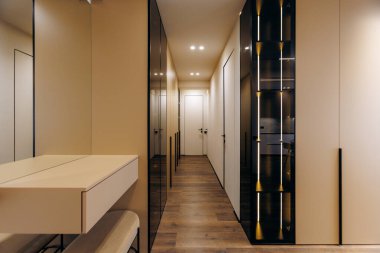 This stylish and contemporary hallway showcases sleek storage solutions complemented by warm and inviting lighting