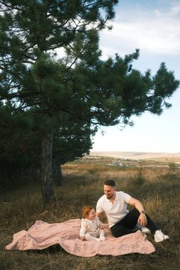 A tender, genuine and heartfelt moment shared between a loving parent and their child in a serene, natural landscape
