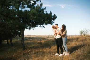 A loving family shares a joyful outdoor moment, beautifully capturing the essence of their togetherness