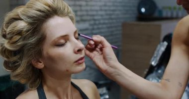 A tranquil and serene moment is captured where a skilled makeup artist is enhancing a models natural beauty