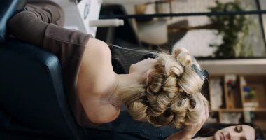 In a stylish salon, a woman shows her chic hairstyle, highlighting elegance and current beauty trends