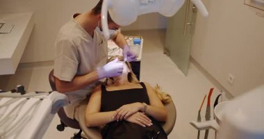 A dental care professional skillfully treats a patient using advanced, innovative tools in a comfortable clinic setting