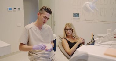 In a modern, sleek clinic, a dental professional expertly discusses treatment options with a patient