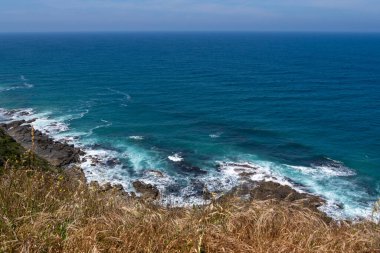 Güneşli bir günde Avustralya 'da Büyük Okyanus Yolu' ndaki kayalara vuran dalgalara bakıyorum.