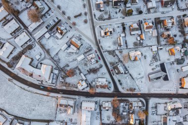 İsveç 'teki küçük Avrupa köyüne kışın hava manzarası, birçok özel ev. Karlı hava, gün batımı. Sıcak güneş ışığı. 