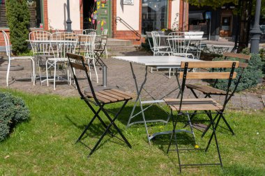 Sandalyeler ve açık havada dinlenmek için masa. Rahatlatıcı bölge. Sıcak ve rahat bir atmosfer. Güneşli bir gün. Kafe. 