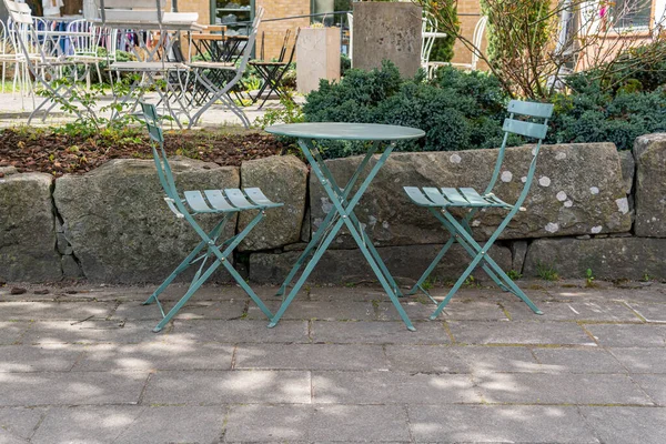 Sandalyeler ve açık havada dinlenmek için masa. Rahatlatıcı bölge. Sıcak ve rahat bir atmosfer. Güneşli bir gün. Kafe. 