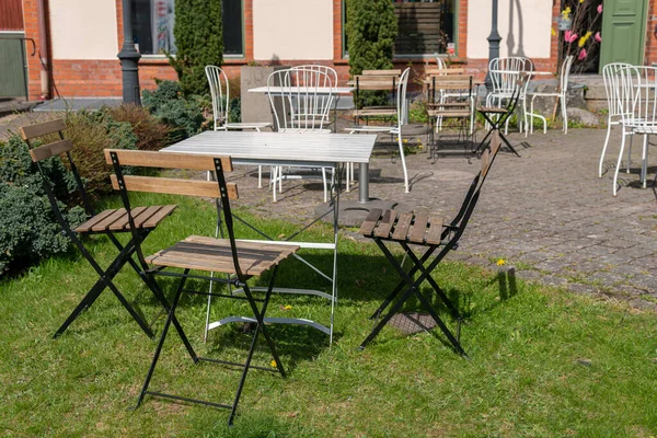 Sandalyeler ve açık havada dinlenmek için masa. Rahatlatıcı bölge. Sıcak ve rahat bir atmosfer. Güneşli bir gün. Kafe. 