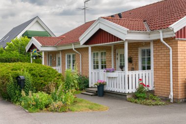Sweden, Knislinge  July 3, 2022: Beautiful yard of a private house in Europe. Stylish architecture, concept of a building. Decorated facade. A lot of greenery and flowers on a summer day. Urbanism, urban area. 