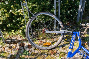 Sweden, Knislinge  August 22, 2022: A broken abandoned bicycle with bent wheel parked outdoors laying on the ground