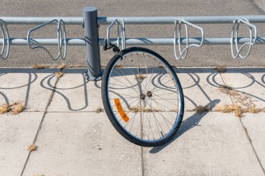 Sweden, Knislinge  August 22, 2022: A stolen bicycle on a parking, only a wheel is left. Vandalism, common problem in big cities.