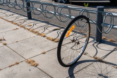Sweden, Knislinge  August 22, 2022: A stolen bicycle on a parking, only a wheel is left. Vandalism, common problem in big cities.
