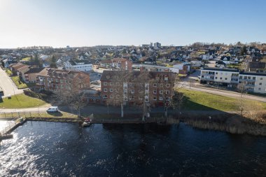 Aerial view on a little town in Europe, Sweden on a spring sunny day. Residential buildings, private houses. Lake and dam near residential house. 