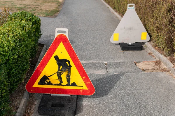 Road work sign outdoors, minor slight damage of a walking road, repair of the bicycle path