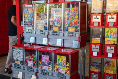 Sweden, Knislinge  September 5, 2022: Old vintage gaming machine in a shop. Claw crane. Candies and bubble gums machine. Big candy dispenser, gumball bank, gumball dispenser. clipart