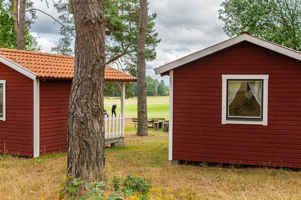 stock image Tiny little red wooden houses in Scandinavian Swedish style near a golf course. Vintage, cozy housing. Ideal place for introverts. 