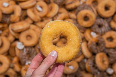 Tatlı ve lezzetli yuvarlak çörekler, şekerle kaplı halka çörekler. Çikolatalı donutlu donut. Şekerin sembolü, kızarmış hamur. Bir sürü tatlı, sağlıksız yemek. Gıda atıkları, gıda üretimi.