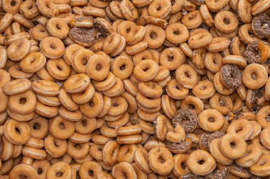 Tatlı ve lezzetli yuvarlak çörekler, şekerle kaplı halka çörekler. Çikolatalı donutlu donut. Şekerin sembolü, kızarmış hamur. Bir sürü tatlı, sağlıksız yemek. Gıda atıkları, gıda üretimi.