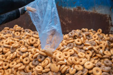 Tatlı ve lezzetli yuvarlak çörekler, şekerle kaplı halka çörekler. Çikolatalı donutlu donut. Şekerin sembolü, kızarmış hamur. Bir sürü tatlı, sağlıksız yemek. Gıda atıkları, gıda üretimi.