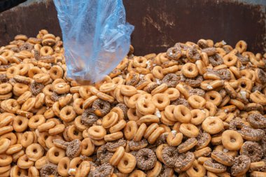 Tatlı ve lezzetli yuvarlak çörekler, şekerle kaplı halka çörekler. Çikolatalı donutlu donut. Şekerin sembolü, kızarmış hamur. Bir sürü tatlı, sağlıksız yemek. Gıda atıkları, gıda üretimi.