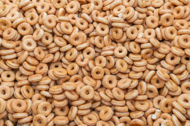 Tatlı ve lezzetli yuvarlak çörekler, şekerle kaplı halka çörekler. Çikolatalı donutlu donut. Şekerin sembolü, kızarmış hamur. Bir sürü tatlı, sağlıksız yemek. Gıda atıkları, gıda üretimi.