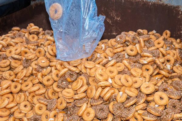 stock image Many sweet and tasty round doughnuts, ring donuts covered with sugar. Chocolate-frosted doughnut. Symbol of sweeties, fried dough. A lot of sweet unhealthy food. Food waste, food production.