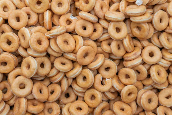 stock image Many sweet and tasty round doughnuts, ring donuts covered with sugar. Chocolate-frosted doughnut. Symbol of sweeties, fried dough. A lot of sweet unhealthy food. Food waste, food production.