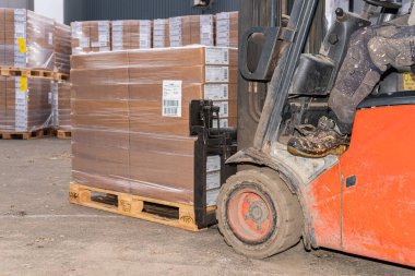 İsveç, Malmö 15 Kasım 2022: Bir depo kaldırma ve karton kutuları taşıma forklift 