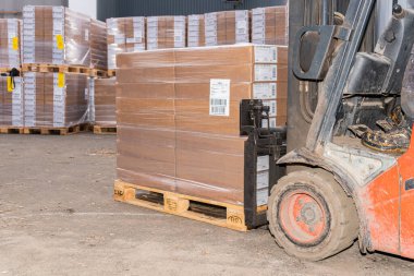 İsveç, Malmö 15 Kasım 2022: Bir depo kaldırma ve karton kutuları taşıma forklift 