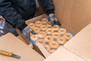 Tatlı ve lezzetli yuvarlak çörekler, şekerle kaplı halka çörekler. Çikolatalı donutlu donut. Şekerin sembolü, kızarmış hamur. Bir sürü tatlı, sağlıksız yemek. Gıda atıkları, gıda üretimi.