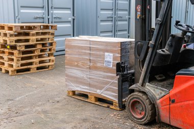 İsveç, Malmö 15 Kasım 2022: Bir depo kaldırma ve karton kutuları taşıma forklift 