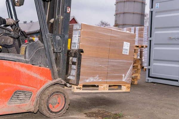 stock image Sweden, Malmo  November 15, 2022: Forklift on a warehouse lifting and moving carton boxes 