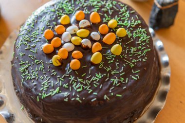 Masanın üstünde küçük yumurtalar olan büyük bir Paskalya pastası. Evde Paskalya kutlaması, gelenekler. Sıcak atmosfer. 