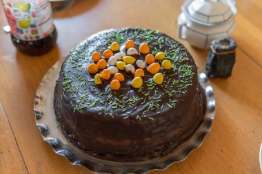 Masanın üstünde küçük yumurtalar olan büyük bir Paskalya pastası. Evde Paskalya kutlaması, gelenekler. Sıcak atmosfer. 