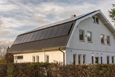 Solar battery panel on a roof of a private house in Europe. Energy-saving technology. Sunny summer day.