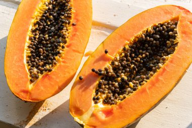 Sıcak ve güneşli bir günde pencere kenarında iki papaya. Papaya ikiye bölündü..