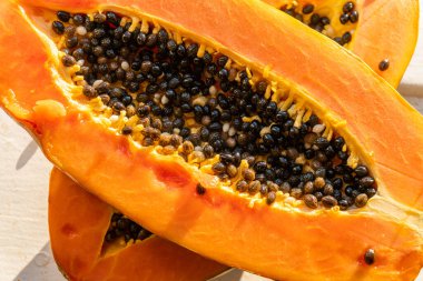 Sıcak ve güneşli bir günde pencere kenarında iki papaya. Papaya ikiye bölündü..