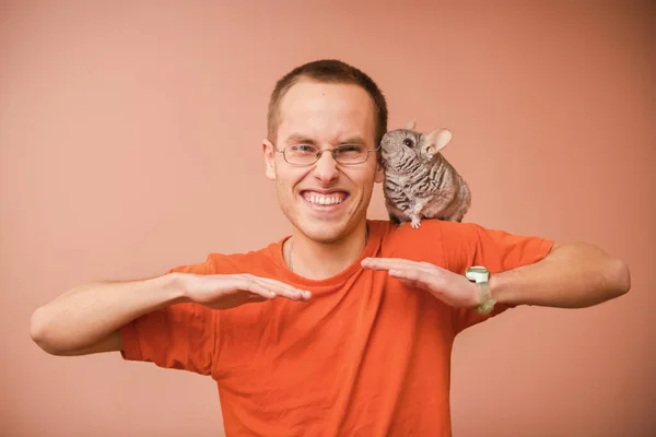 A man is posing with chinchilla. Animal-Assisted, Pet Therapy. Playful and tamed chinchilla.