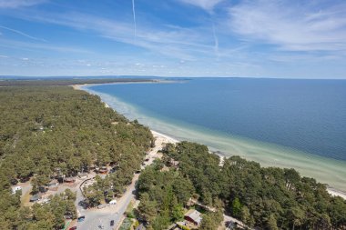 Plaj ve denizin havadan görünüşü. Güzel deniz, deniz manzarası, deniz manzarası. Sahile yakın bir orman. Güneşli bir yaz günü. Tatil ve eğlence alanı. 