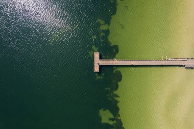 Uzun bir rıhtımın, su setinin, iskelenin havadan görünüşü. Güzel deniz, İHA 'dan sahil manzarası. Tatil ve eğlence alanı.