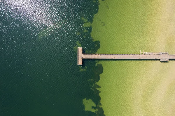 Uzun bir rıhtımın, su setinin, iskelenin havadan görünüşü. Güzel deniz, İHA 'dan sahil manzarası. Tatil ve eğlence alanı.